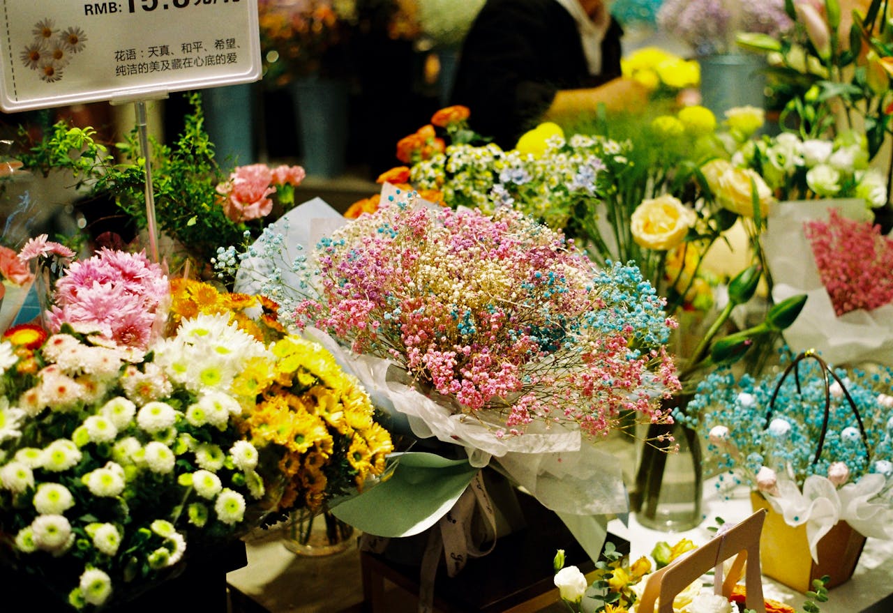 Colorful bouquets including baby's breath and chrysanthemums at an indoor market stall.