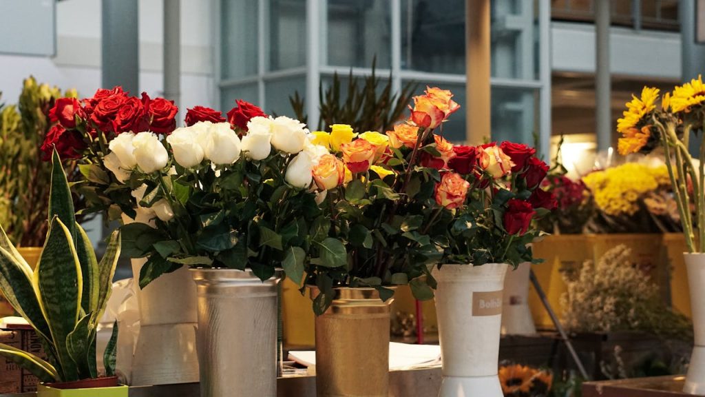 Vibrant mixed roses in vases at a flower shop in Porto, Portugal.